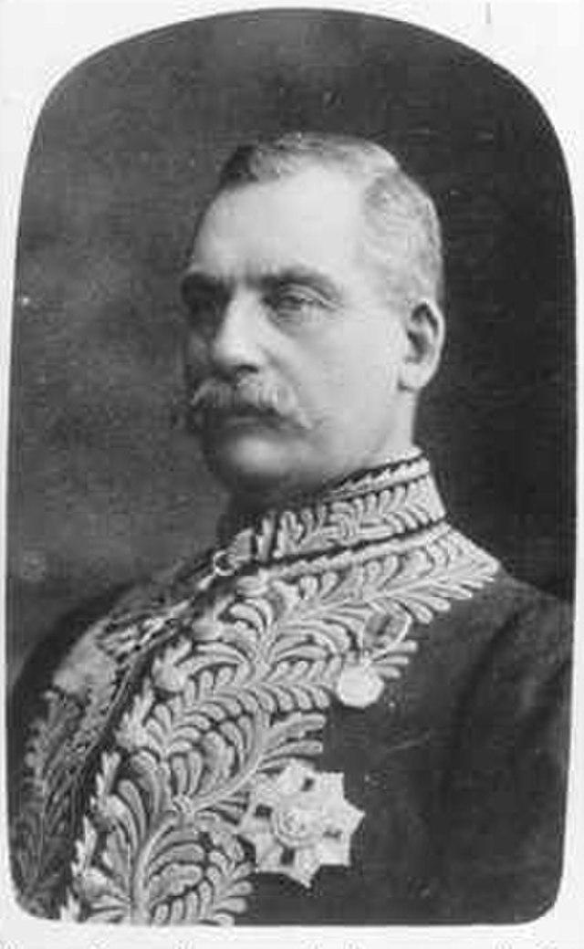 Black-and-white portrait of Sir George Le Hunte wearing an ornate ceremonial uniform decorated with embroidered leaf motifs and official insignia.