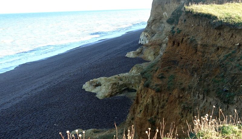 Eroding cliffs along the Norfolk coast showing sediment layers shaped by ancient glacial processes similar to those that formed Doggerland.