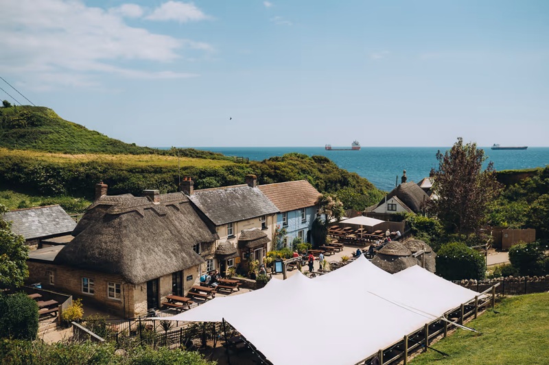 The Smugglers Inn, a historic seaside pub at Osmington Mills near Weymouth on the Dorset coast, with thatched roof and ocean views