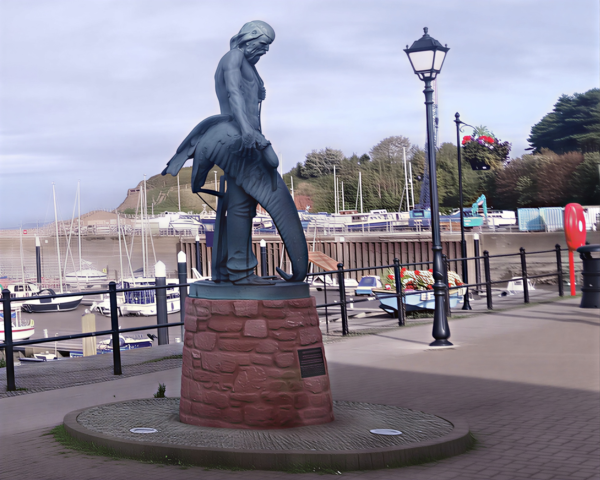 Side view of The Ancient Mariner statue overlooking Watchet Harbour in Somerset