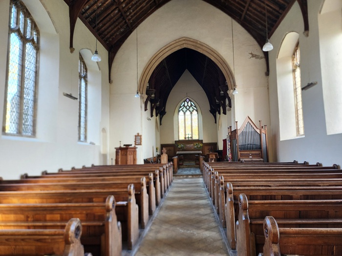 Interior of the Church of St John and St Mary in Stiffkey, showing the nave, wooden pews and medieval chancel.